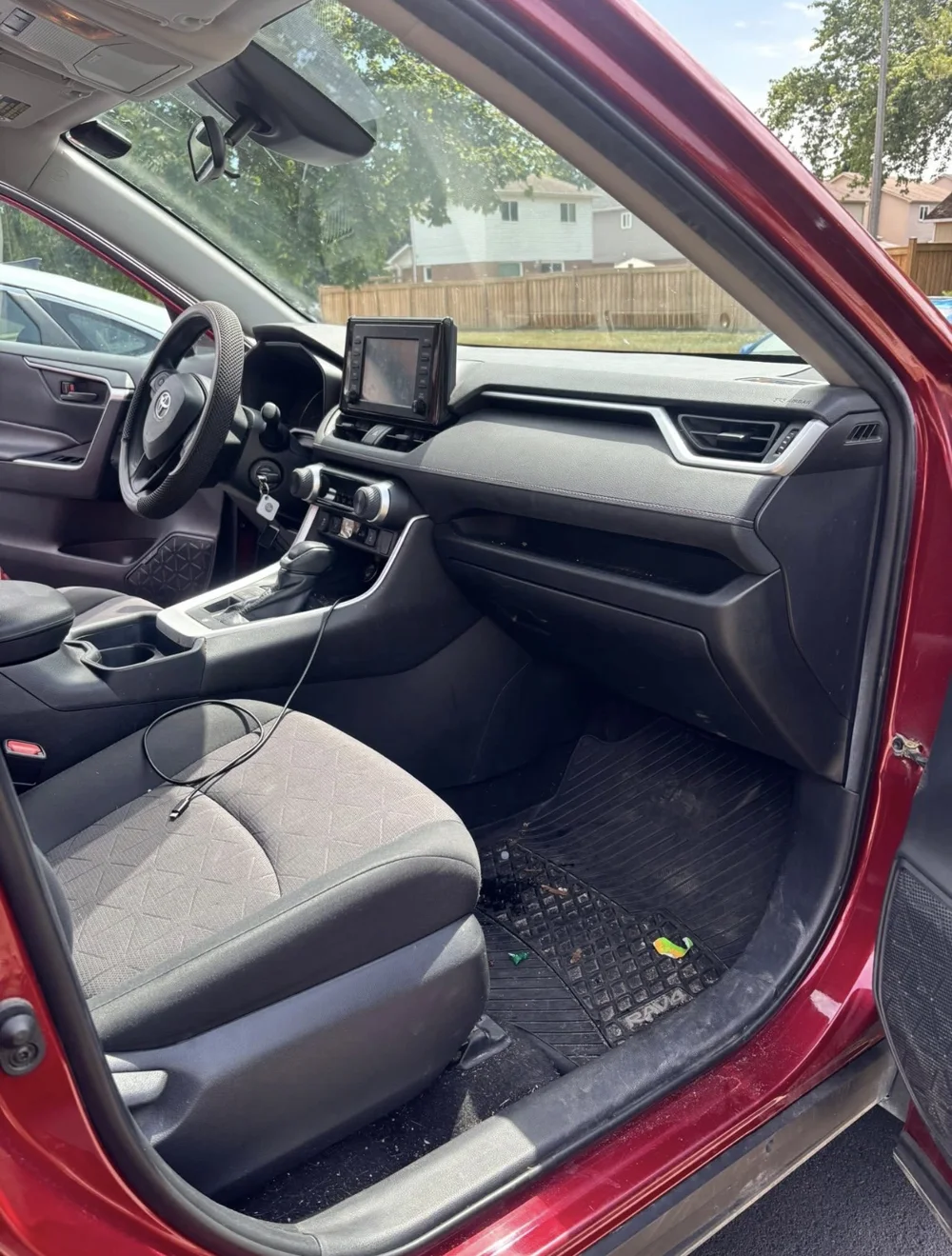 Toyota RAV4 interior before detailing, with a dusty floor mat and dashboard