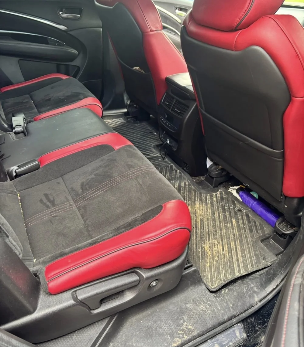 Red and black leather rear seats before detailing, with visible dirt and stains