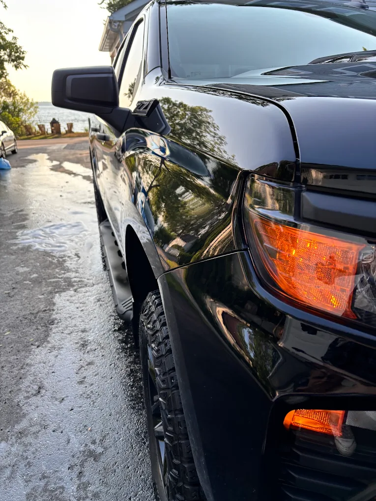 Close-up of a black pickup truck's paint and taillight after an exterior detail