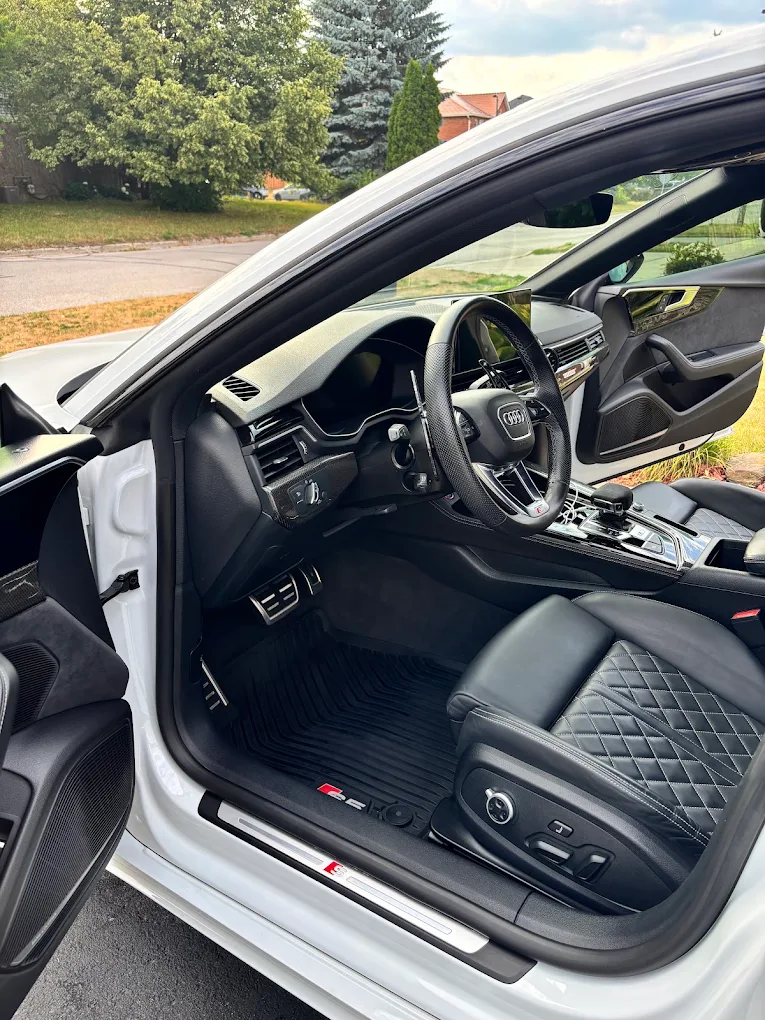 Clean black leather interior and dashboard of an Audi after an interior detail